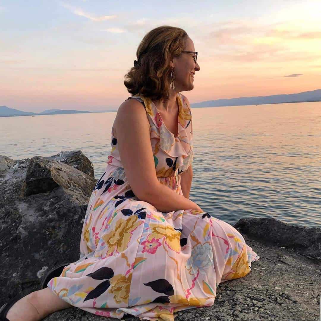 alt="Christine, doula et infirmière, assise au bord du lac de Neuchâtel, pour Tadoulamie.ch, et Famaia.ch"
