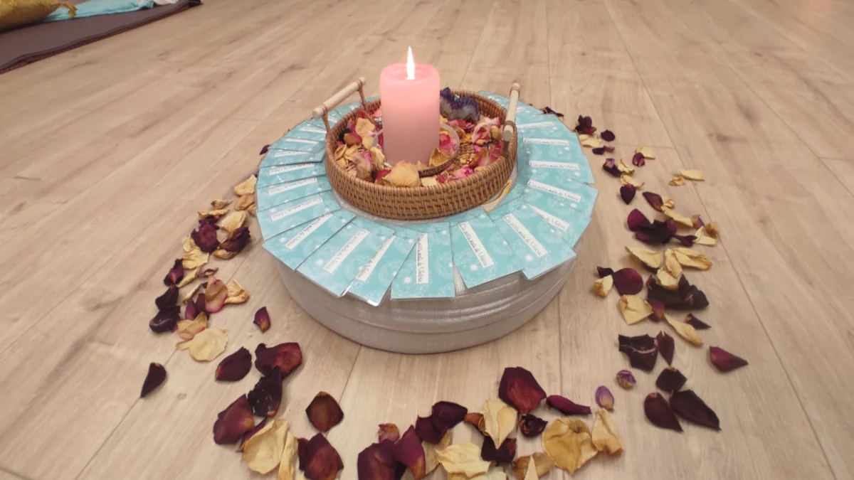 Autel de cercle de femmes avec bougie, cartes de tarot et pétales de rose pour un rituel Tadoualmaie