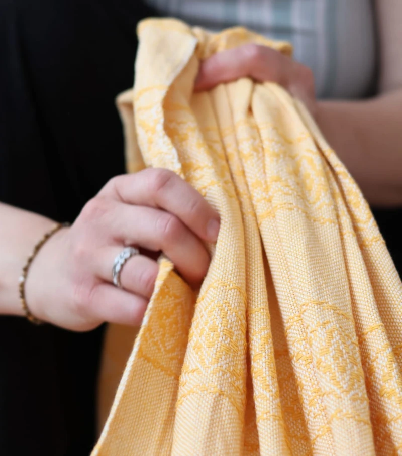 Gros plan du tissage artisanal d'un rebozo jaune en coton, écharpe mexicaine traditionnelle
