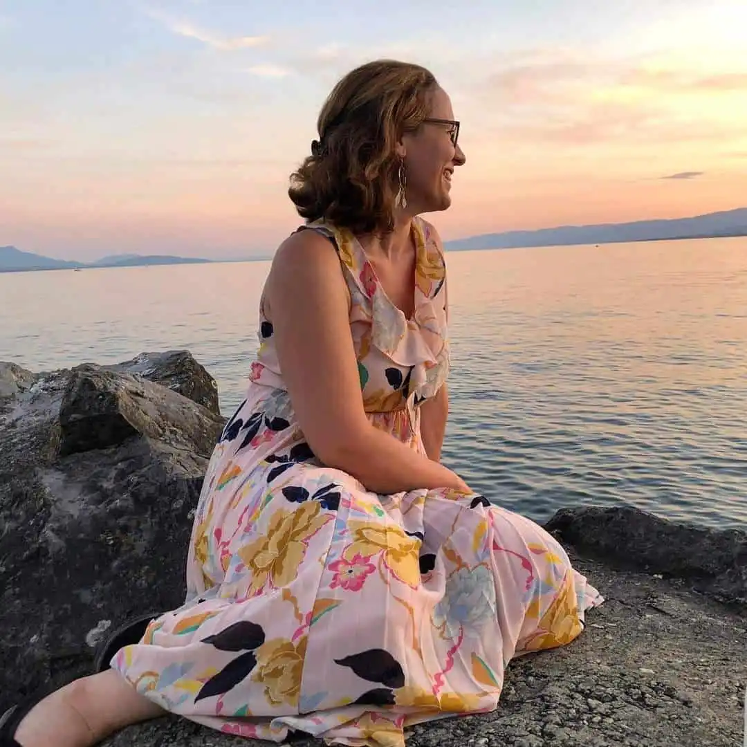 Christine Grandjean, doula et infirmière, assise au bord du lac de Neuchâtel